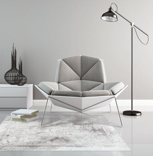 Nowoczesny szary dywan Beto z przetarciami w minimalistycznym salonie z designerskim fotelem i lampą podłogową.